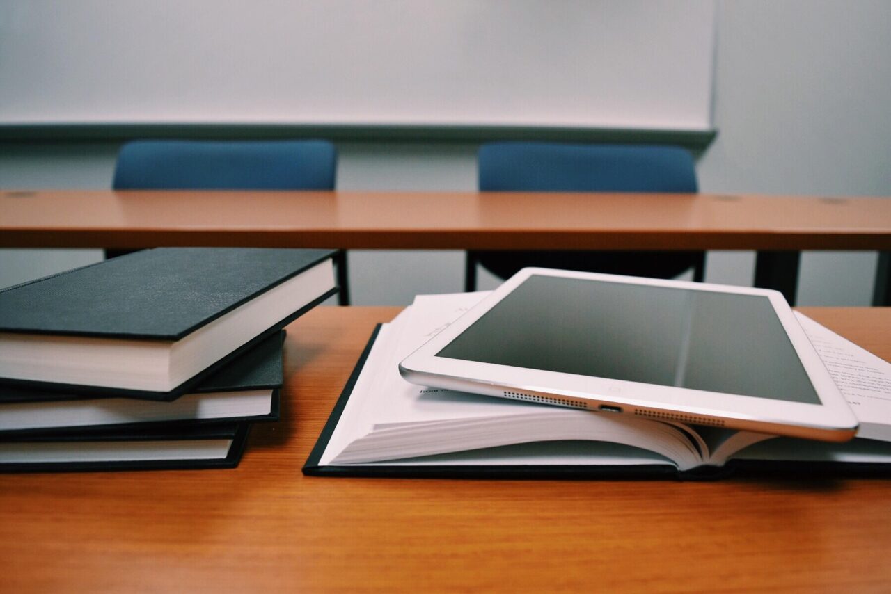 Escritorio con libros abiertos y portátil, simbolizando la transformación educativa con inteligencia artificial.