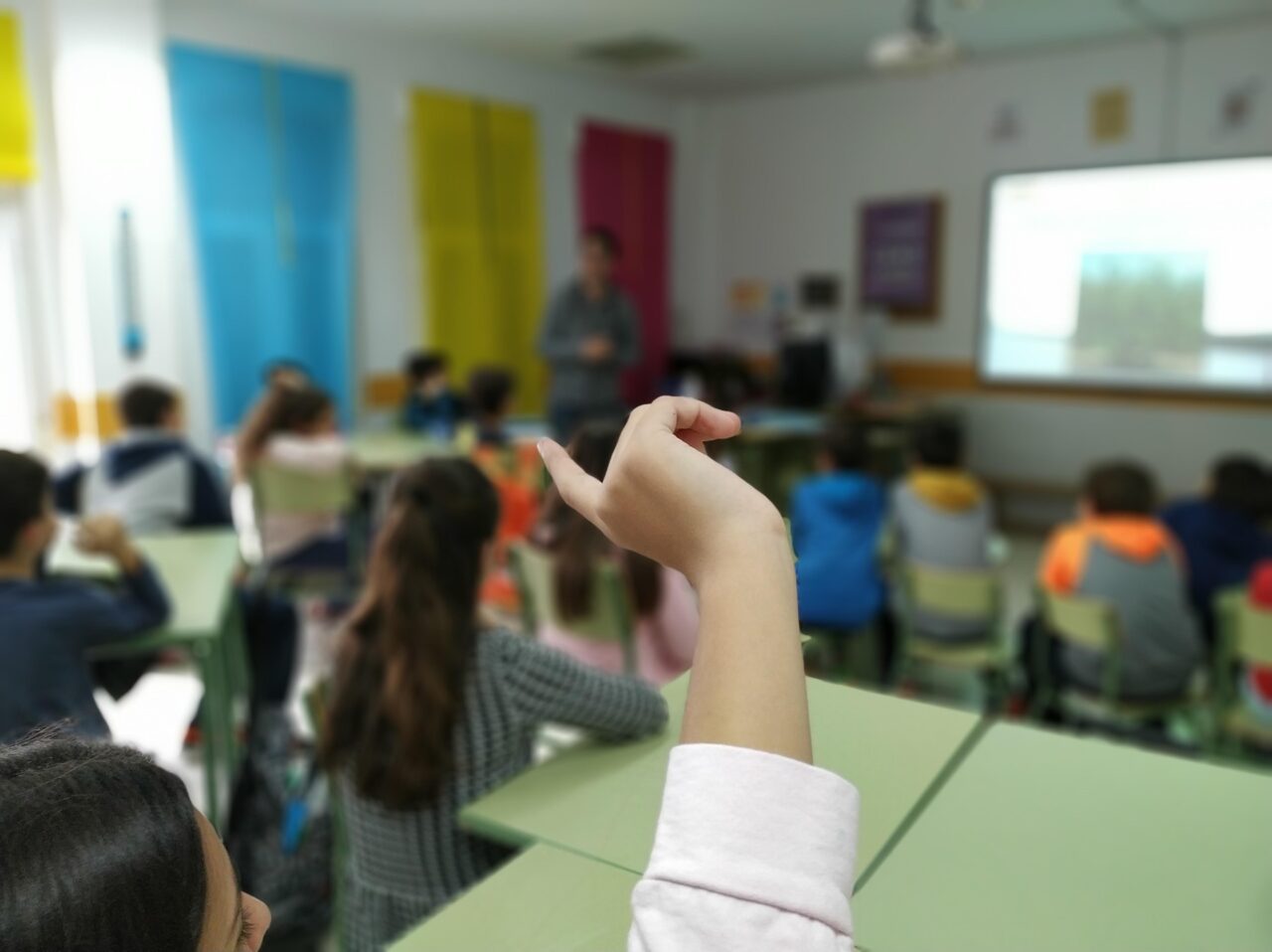 Aula con estudiantes y profesora al frente, ilustrando una escena de enseñanza tradicional, en el contexto de una crítica al sistema educativo.